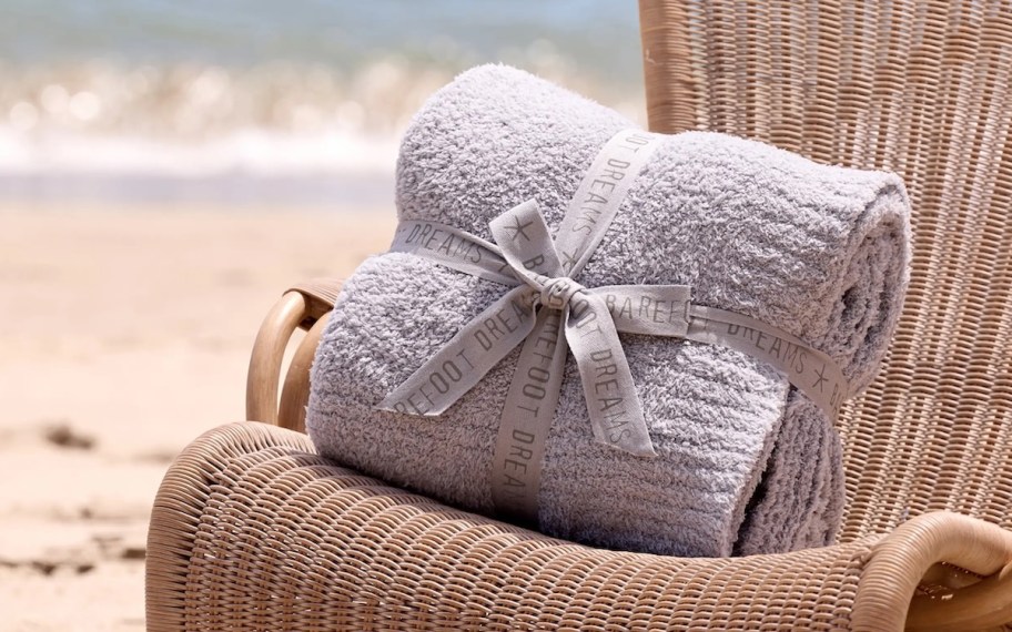 Grey barefoot dreams, blanket sitting on beach chair in sand