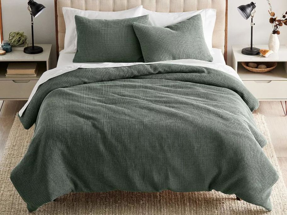 green comforter and shams on bed