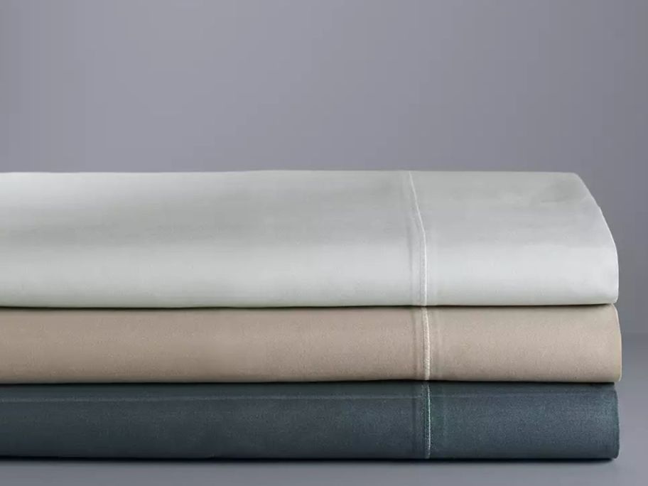 grey, beige, and green sheets stacked on top of each other