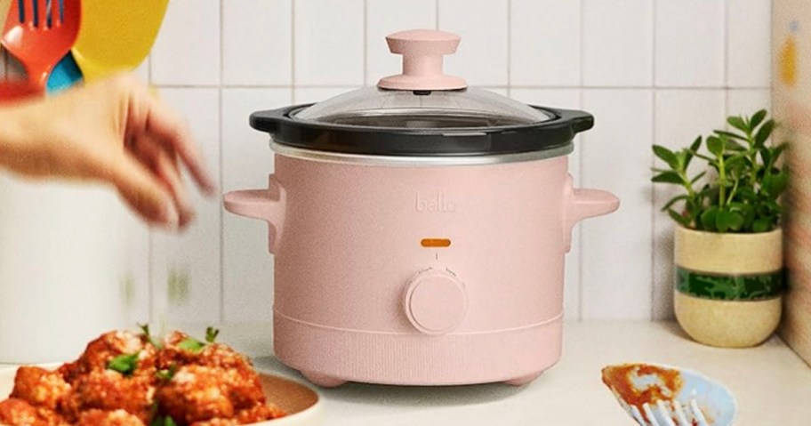 pink slow cooker on countertop