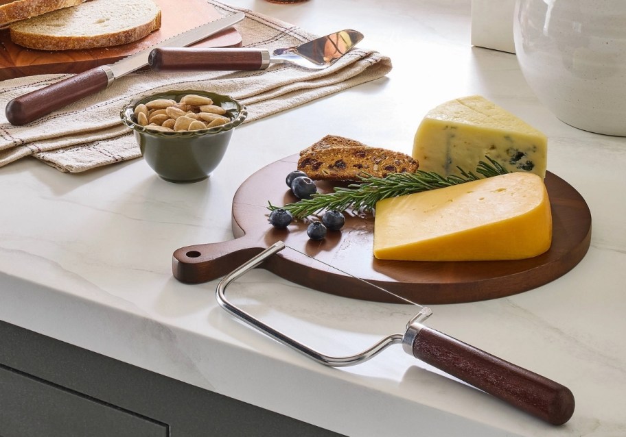 a 3 piece cheese knife set shown with foods