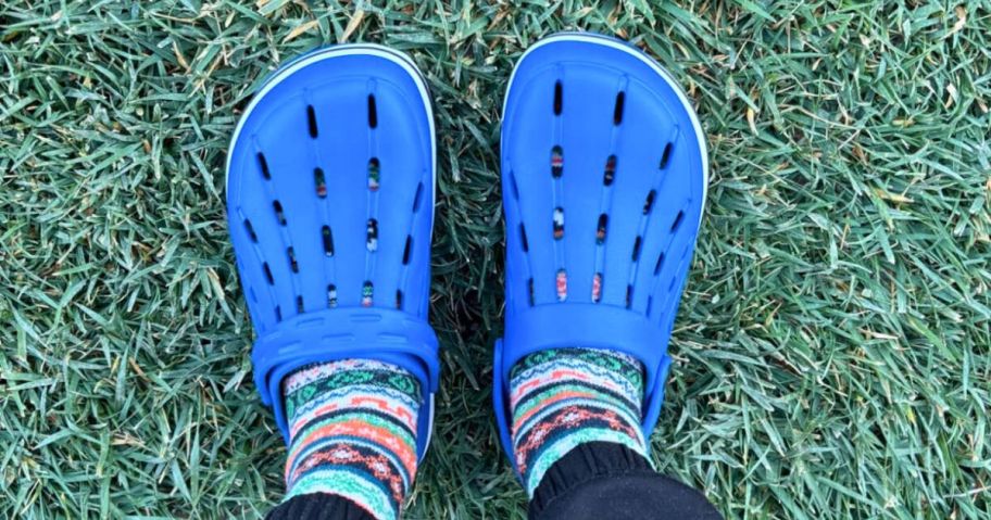 kid wearing blue clogs on grass
