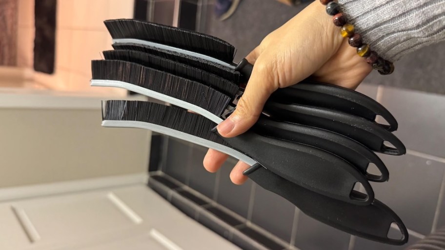 holding several crevice cleaning brushes