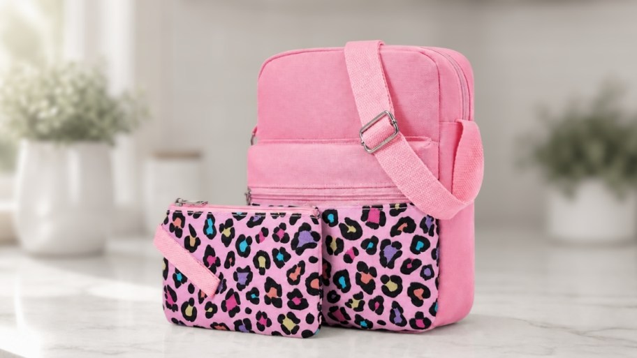 girls pink and leopard print crossbody bag and pouch on a counter top