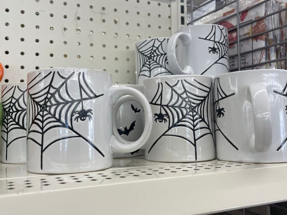 Halloween Mugs with spiderwebs on them on shelf in store