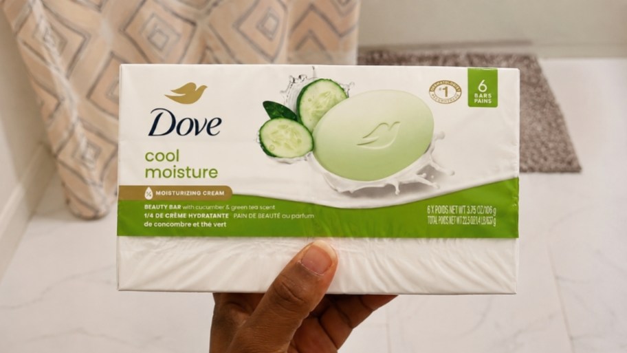 a womans hand holding a 6 count pack of dove soap