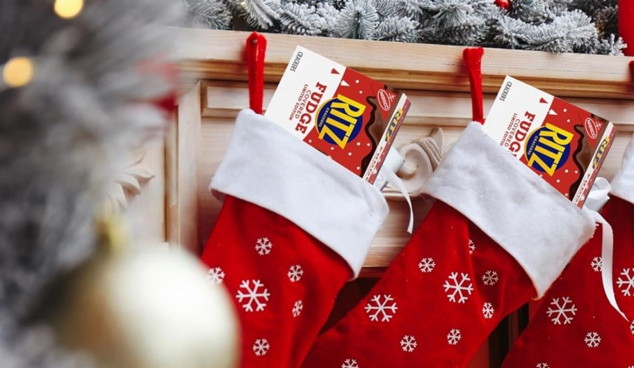 a box of crackers sticking out of a christmas stocking hung by the fireplace