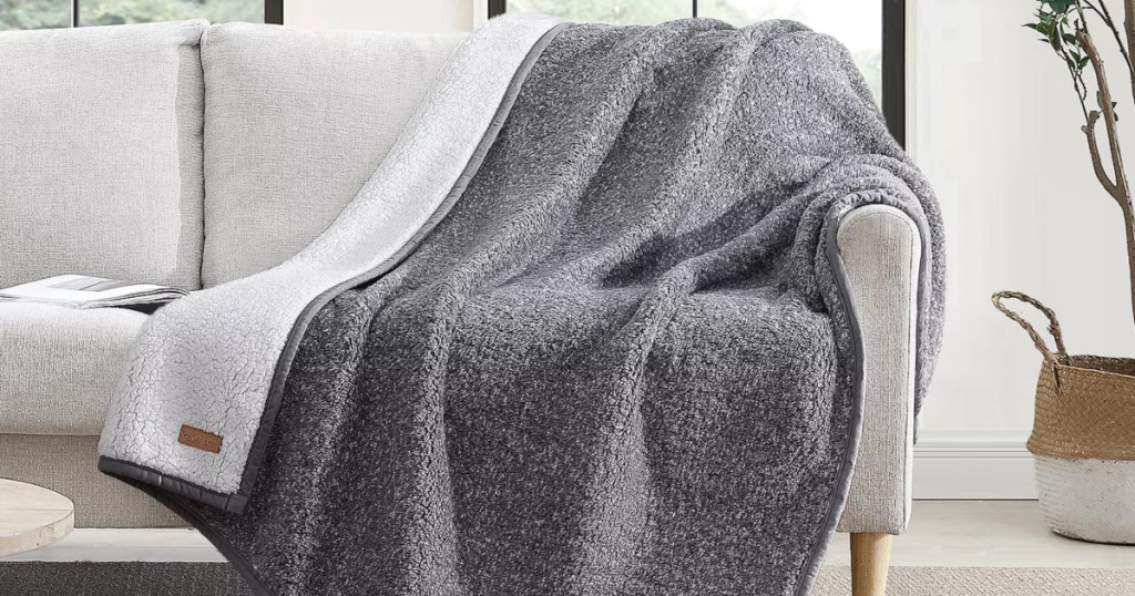 Grey ugg throw blanket draped on couch