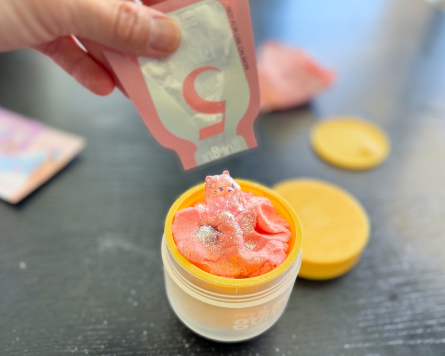 hand pouring glitter into slime