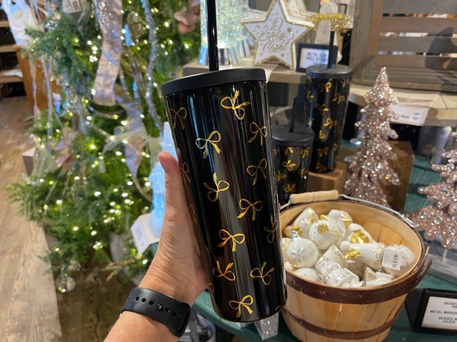 a womans hand holding an insulated tumbler