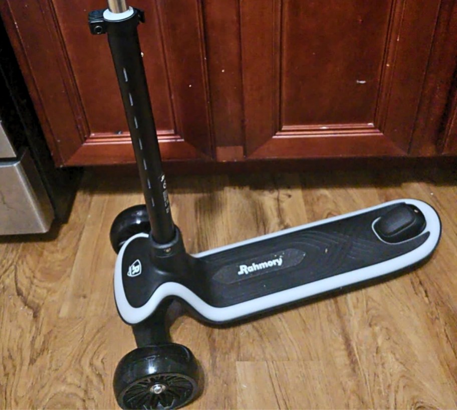 a kids light up scooter next to a lower kitchen cabinet
