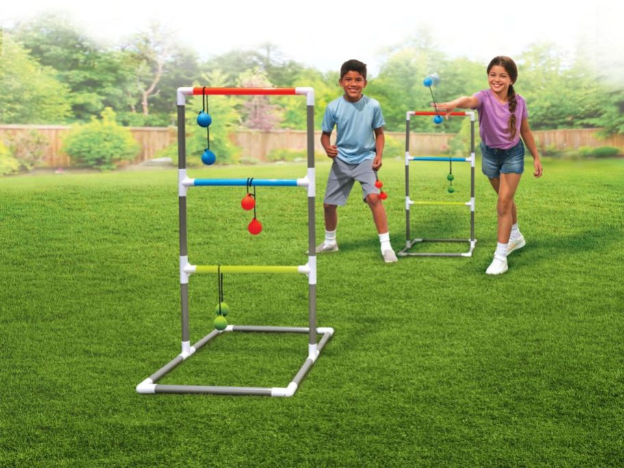 two kids playing ladder ball on grass