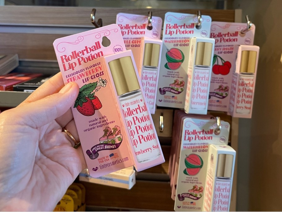 womans hand holding a lip gloss roller