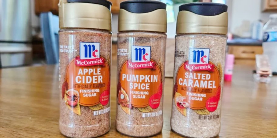 mccormick apple cider, pumpkin spice, and salted caramel finishing sugar containers on table