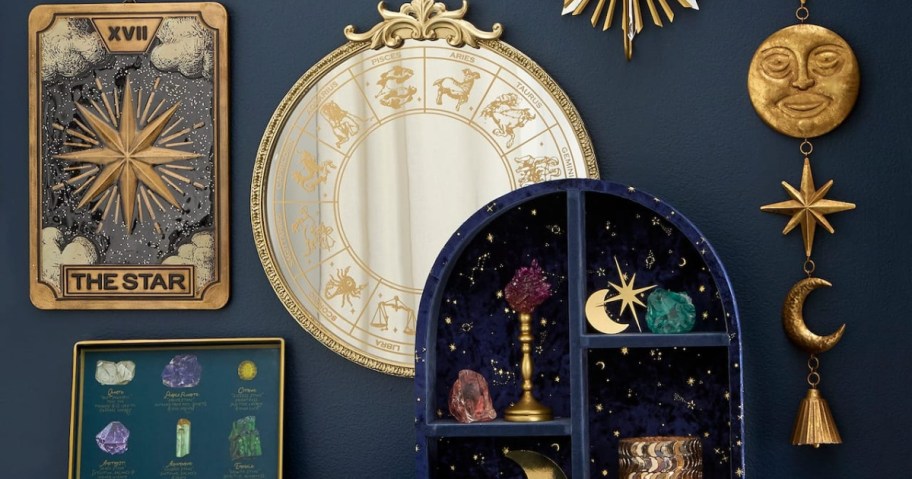 Mystical gold and blue wall decor including a "The Star" tarot card plaque, a round zodiac mirror, a celestial display shelf with crystals, and a sun and moon hanging mobile.