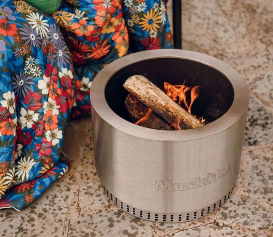 a smokeless fire pit on a patio with a fire burning inside it