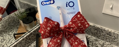 oral b series 3 rechargeable electric toothbrush with a red bow tied around
