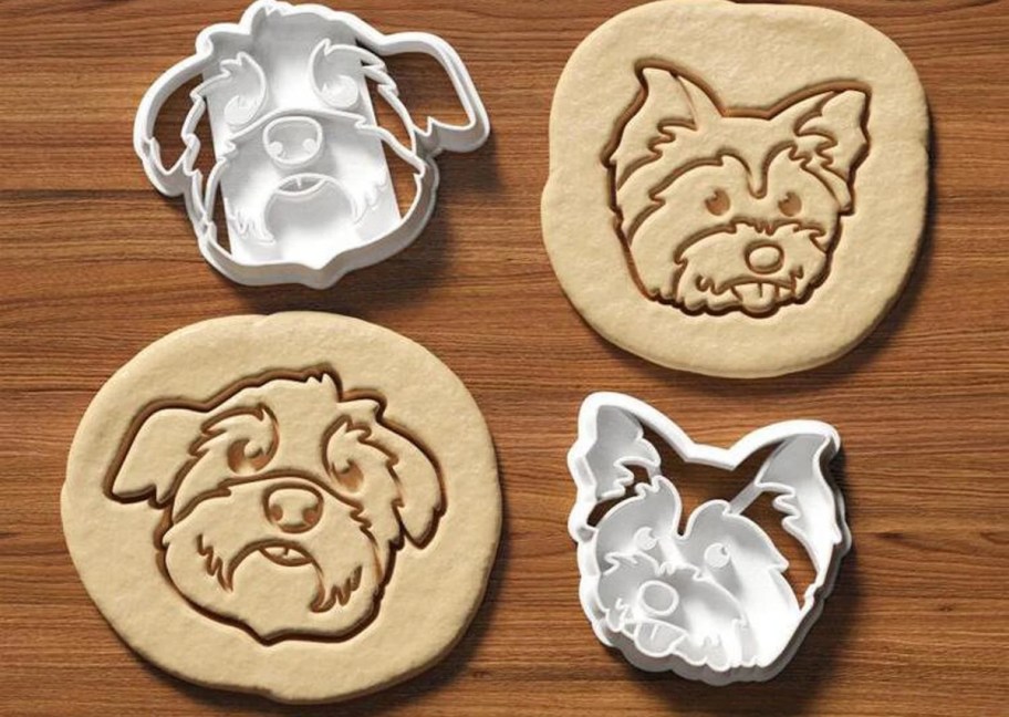 pet shaped cookie cutters with cookie dough on wood table