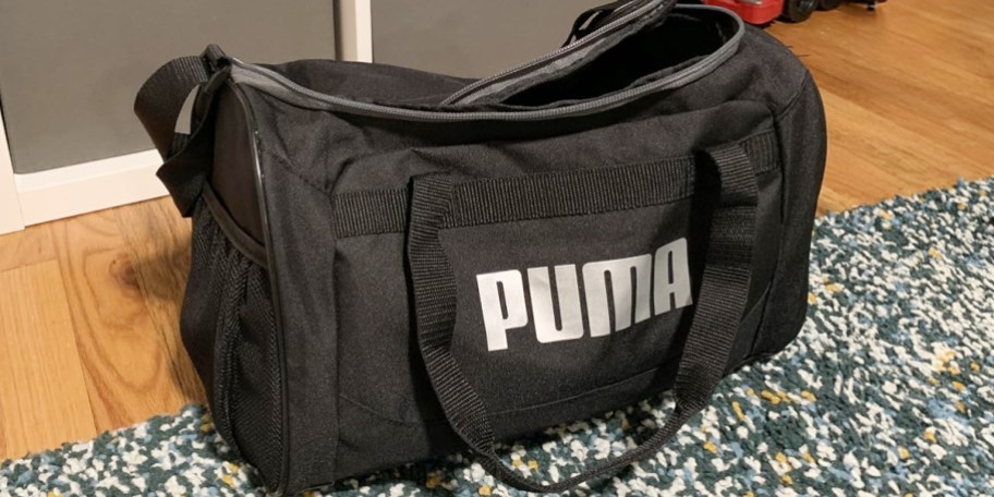 black PUMA duffel bag laying on rug