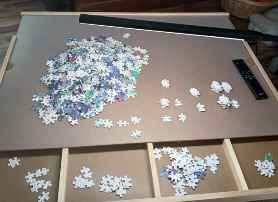 a 4 drawer puzzle table with puzzle pieces on the top and in the drawers