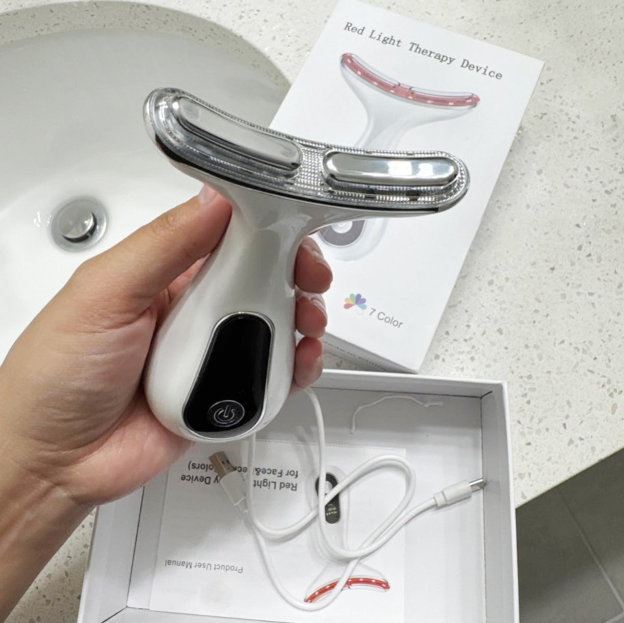 hand holding a red light therapy wand