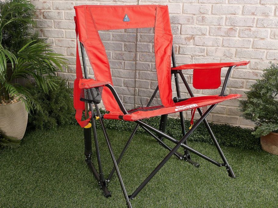 rocking outdoor chair in orange displayed outside