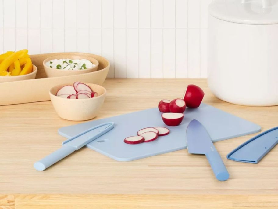 blue Room Essentials 3-Piece Cutlery Knives & Cutting Board Set with radishes on it on counter