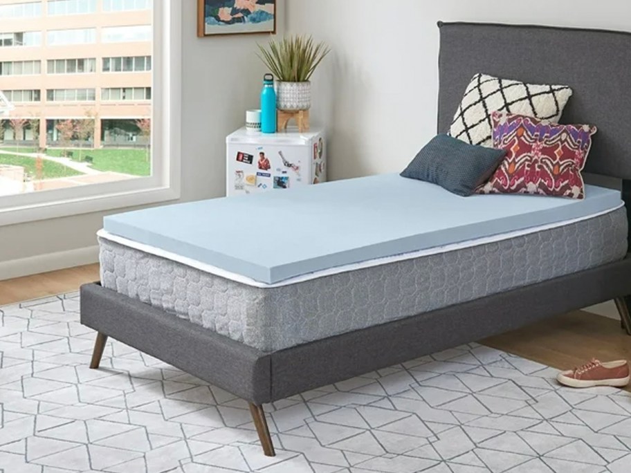 blue mattress topper on bed with gray throw pillows