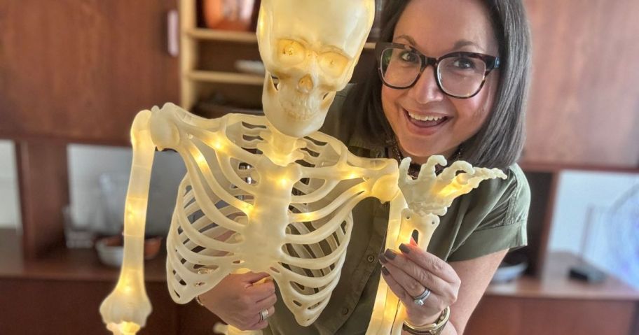 woman holding lit up skeleton