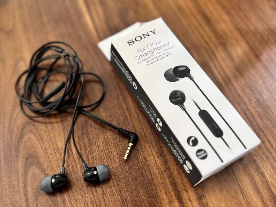 black sony earbuds on table next to box on table