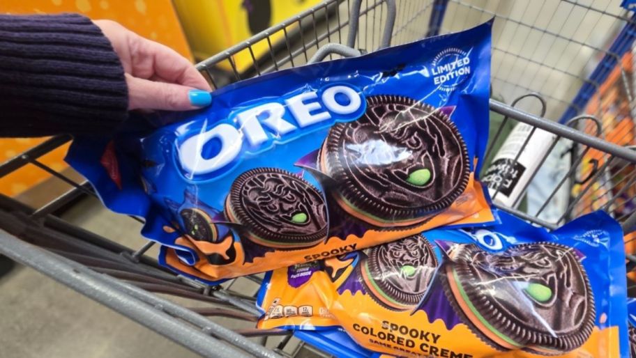 a womans hand holding a snack pack bag of oreos