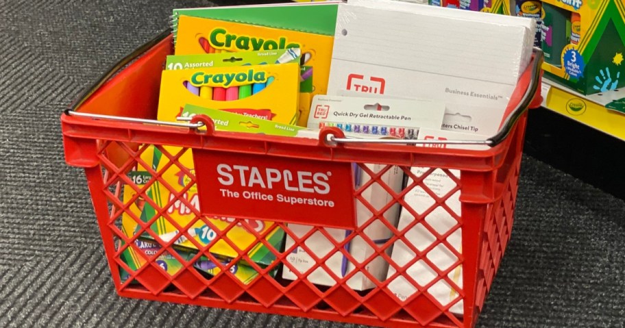 a Staples shopping basket with various school supplies in it