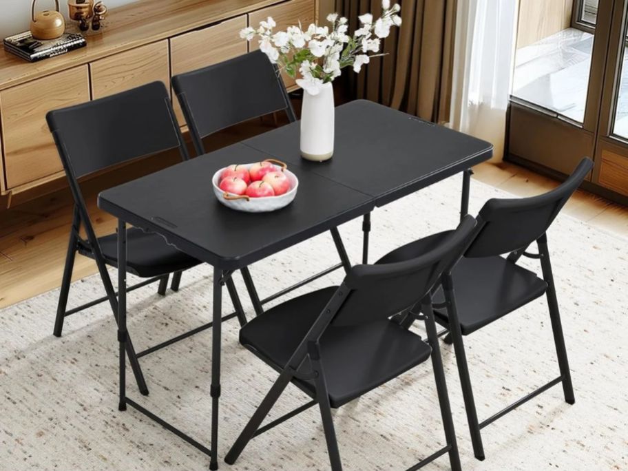 4 foot black table in dining room with chairs around it
