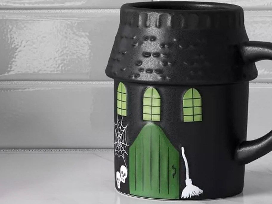 black haunted house mug on countertop