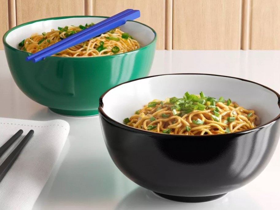 green and black noodle bowls on table