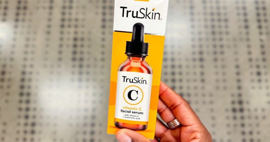 person holding a bottle of truskin vitamin c serum