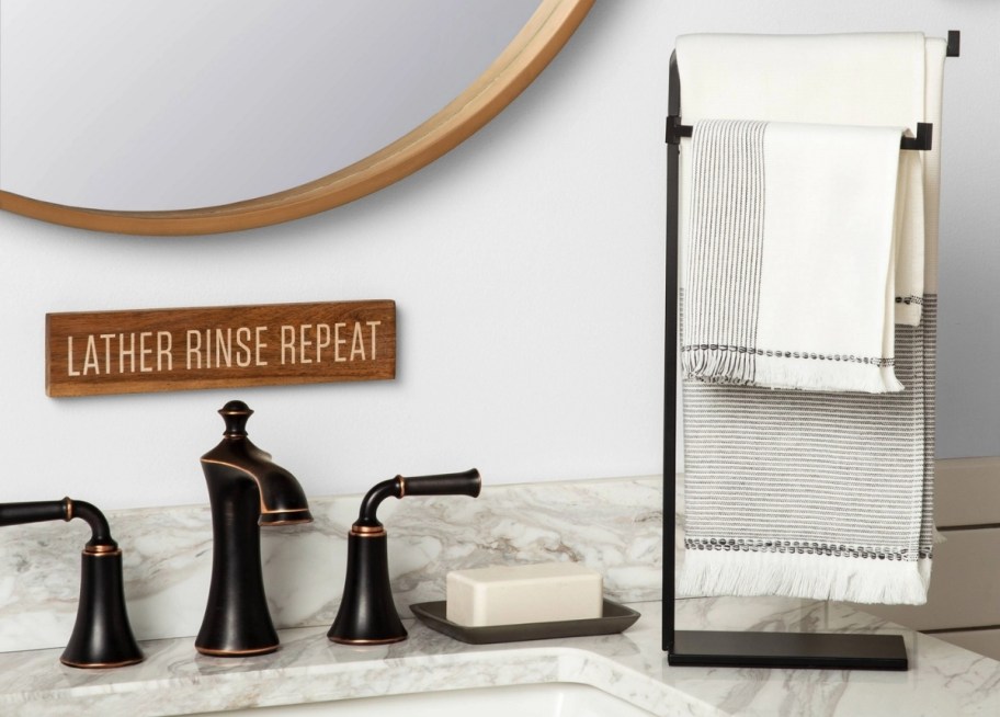 black metal towel stand next to a bathroom sink