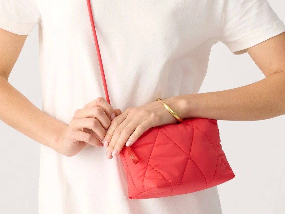 woman with a coral pink crossbody bag