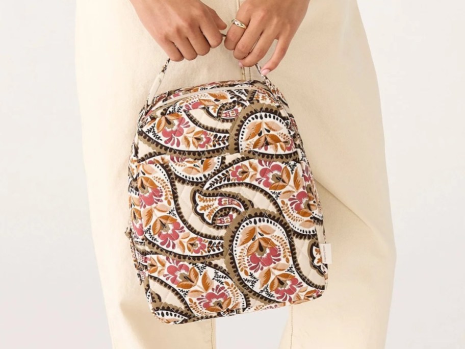 woman holding a floral paisley lunch bag
