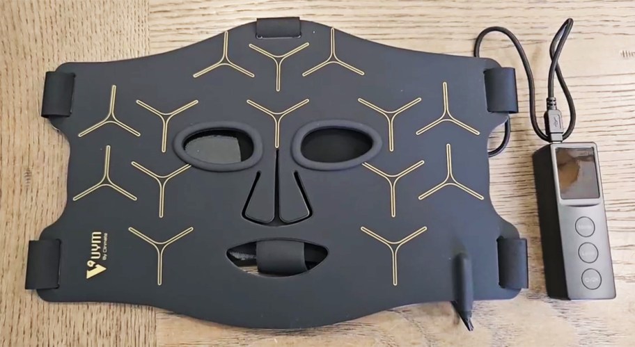 black red light therapy mask on a table with remote