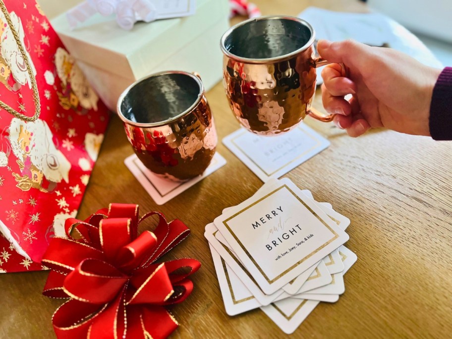 picking up a copper mug from a custom coaster