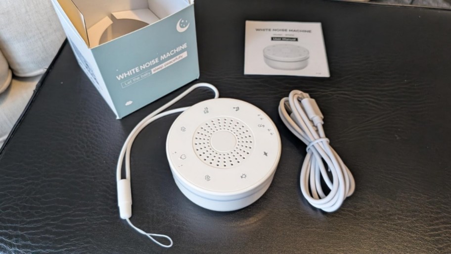 a white noise machine shown with charging cable, instruction booklet and box.