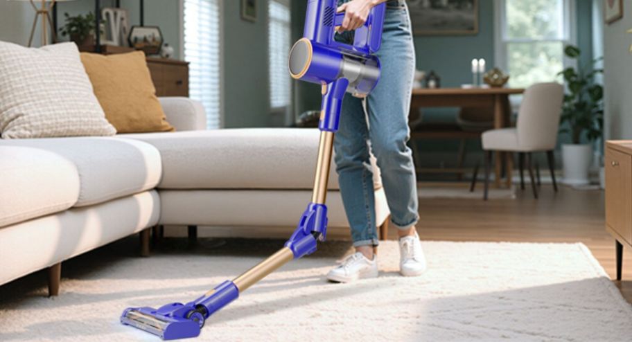 woman using wireless vacuum around her carpet