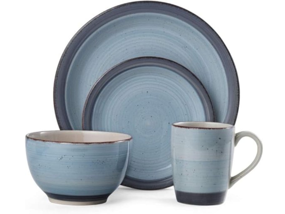 a set of blue stoneware dinnerware with plates, bowl, and mug