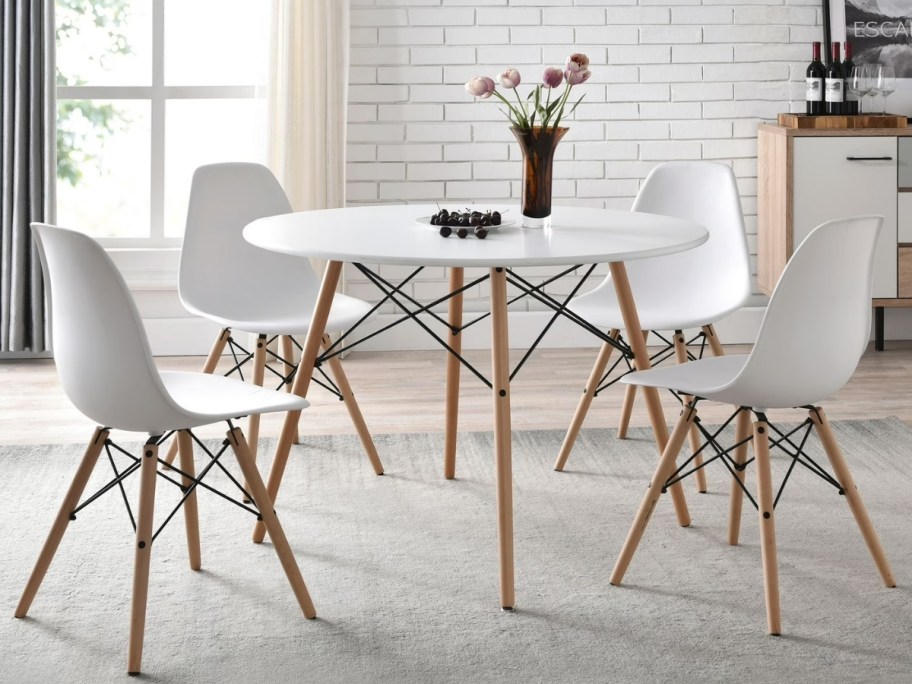 four white chairs around a white table