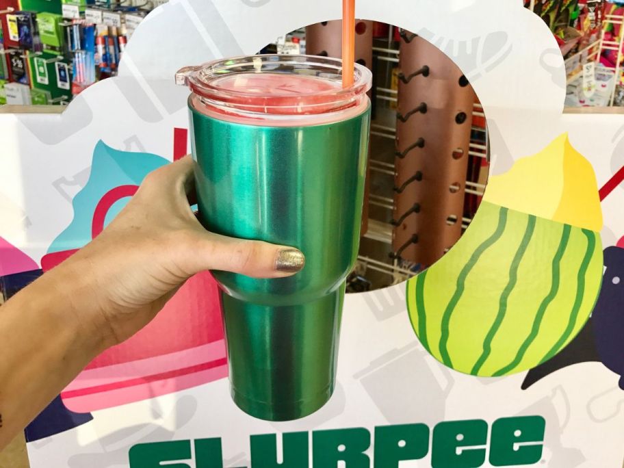 Hand holding a huge tumbler filled with Slurpee from 7-Eleven