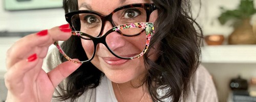 A woman putting on a top frame to her pair eyeglasses