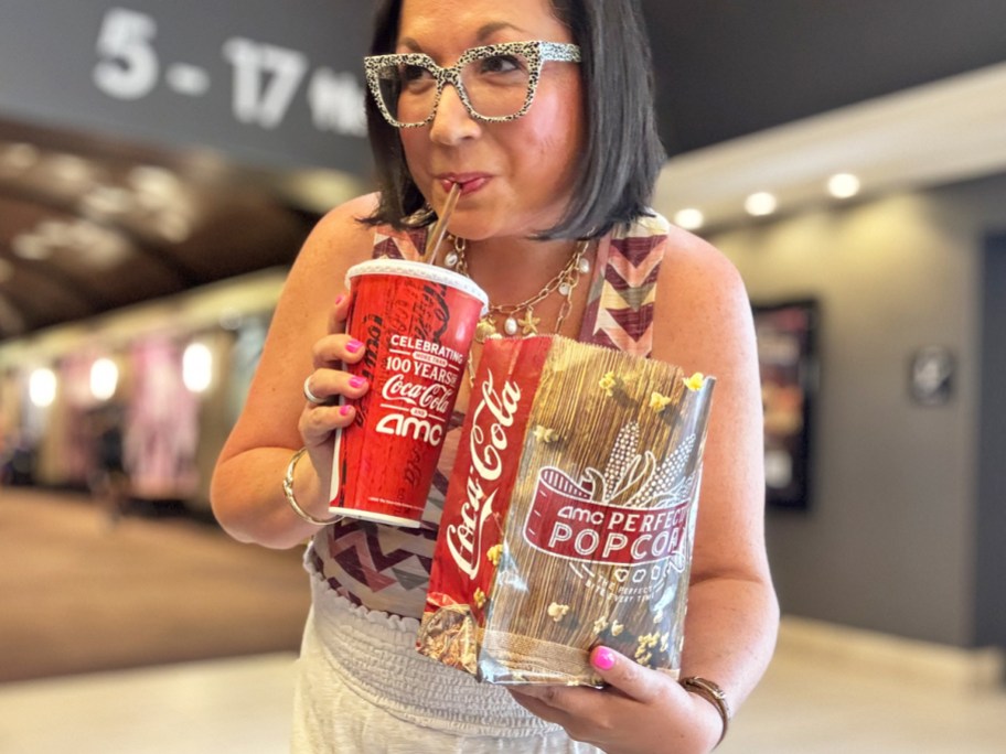 woman holding an AMC drink and popcorn bag