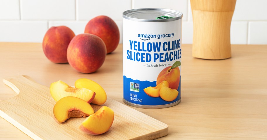 can of Amazon Grocery peaches on counter near peach slices