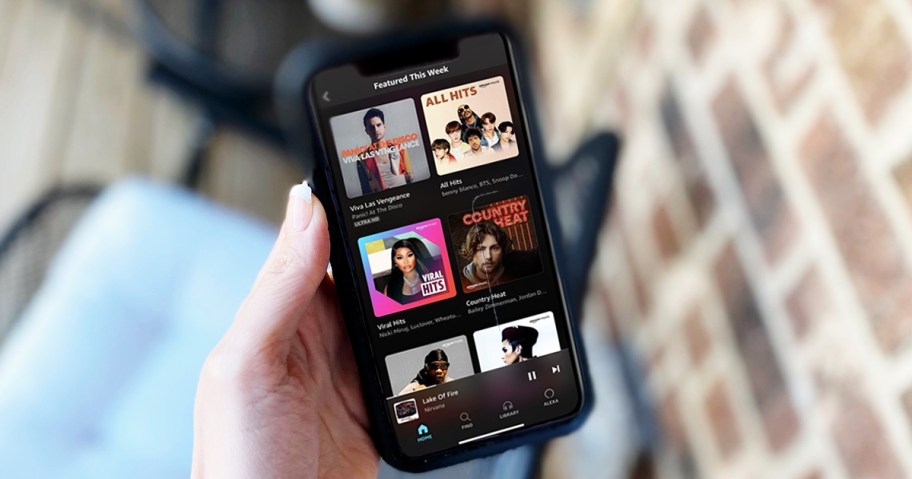 hand holding an iPhone with the Amazon Music Unlimited app open